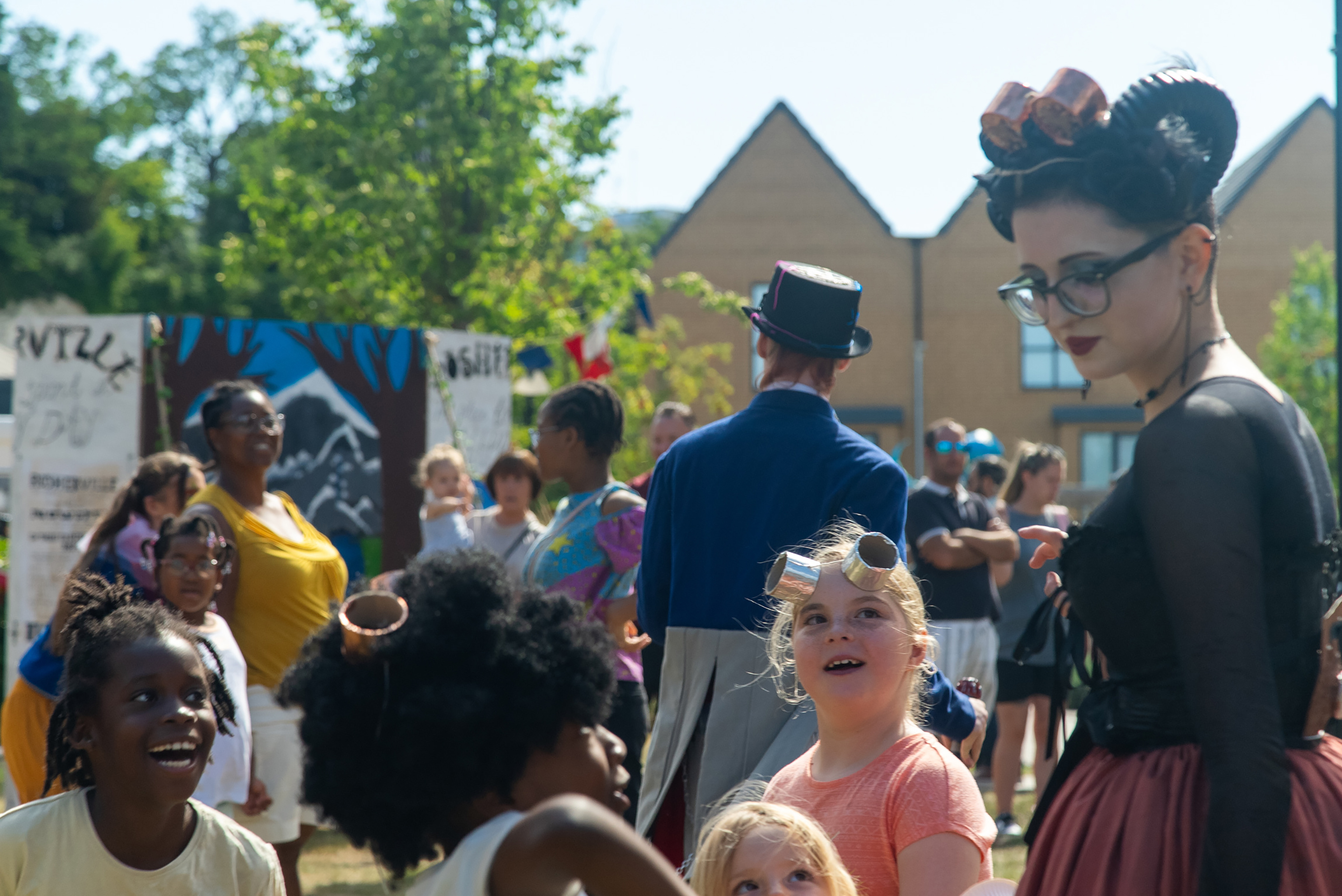Children looking up at a performer wearing a costume