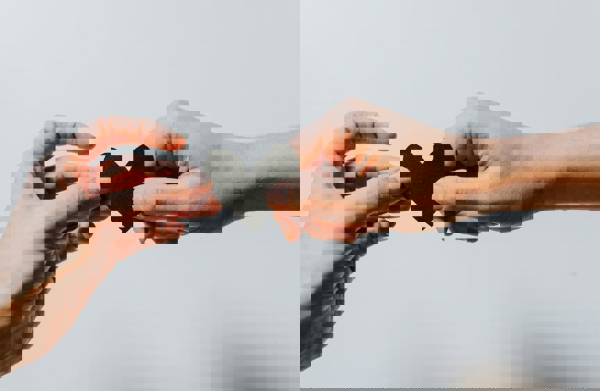 two hands holding a cut out heart shape