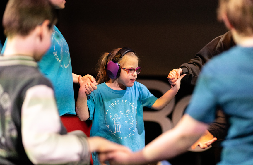 Little girl sat on the floor giving a thumbs up