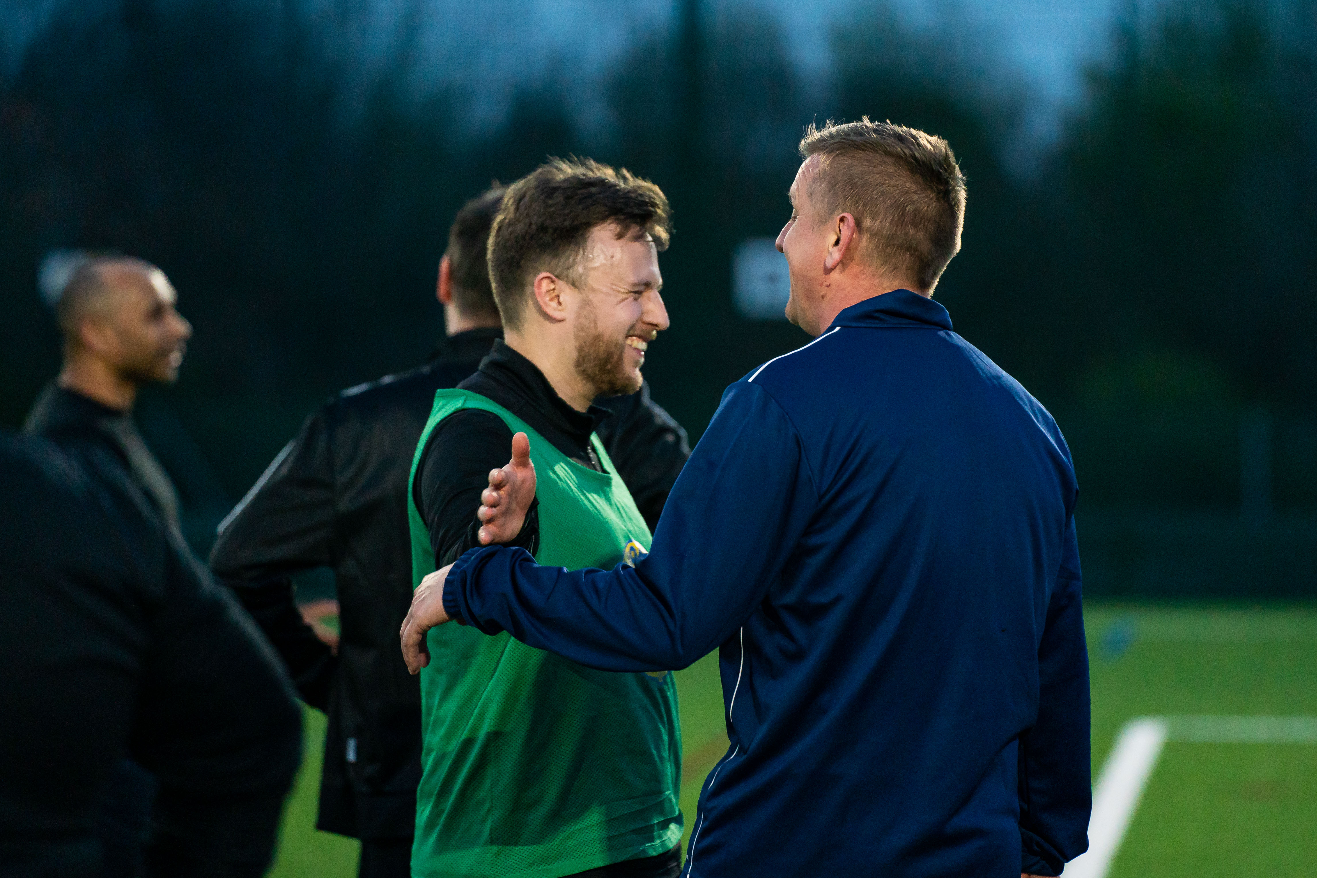 Men smiling and going to hug each other