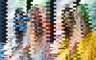 Two smiling women collaborating on a project