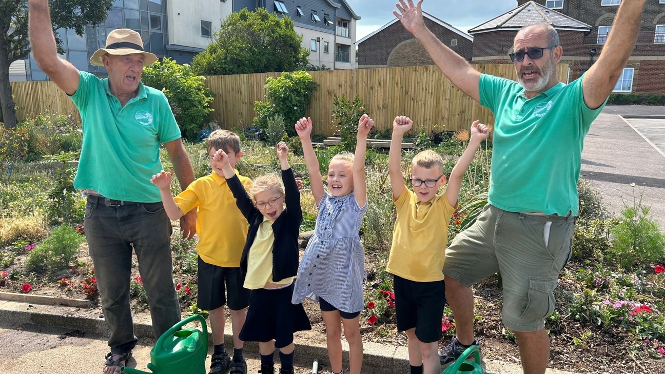 Wilderness to Wonderland - volunteers and children cheering in the garden