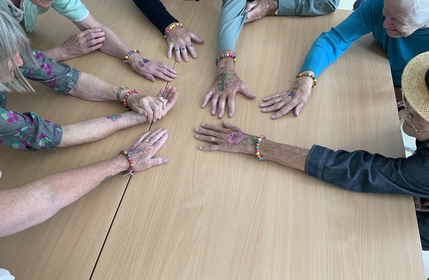Lots of hands with drawings on stretched on a table