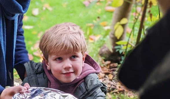 Little boy handing over a plate of food